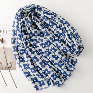 Detail of navy blue floral scarf with gold foil dots and fringe edges on a magazine