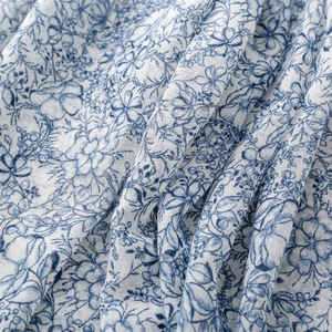 Close-up of blue floral cotton linen fabric with fine blue porcelain style print
