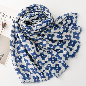 Close-up of blue and white floral scarf with gold foil dots and natural frayed edges