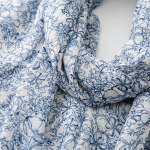 Close-up of blue floral cotton linen scarf showing delicate texture and weave detail