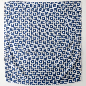 Detail of navy and white floral silk scarf with golden dot patterns and fringe edges