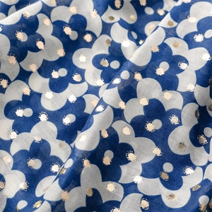 Macro shot of navy floral fabric with elegant gold foil polka dots and soft pleated texture
