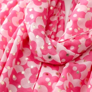 Macro detail of floral pink scarf with gold foil polka dots and soft pleated texture