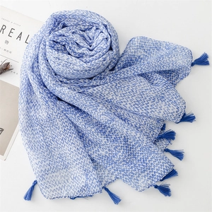 Detailed view of blue wavy patterns and fringe tassels on a cotton-linen feel scarf