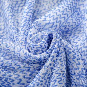 Macro shot of breathable cotton linen fabric with blue wave patterns and fringe detail