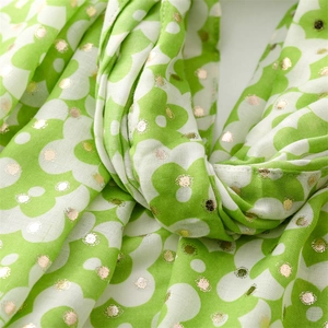 Detailed macro view of green floral scarf with textured cotton-linen and gold foil dots