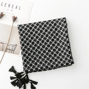 Detail of black and white geometric chain pattern scarf with soft fringe tassels