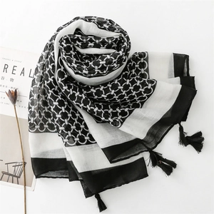 Detail view of cotton-linen scarf featuring geometric chain patterns and tassel fringe