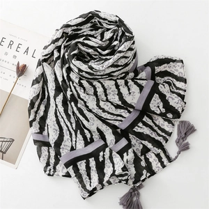 Detailed view of lightweight zebra print scarf featuring grey tassels and thin fabric texture