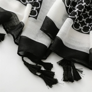 Macro shot of black and white geometric pattern scarf with detailed fringe and soft texture