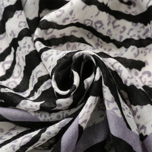 Macro detail of breathable zebra print fabric showing black stripes and purple leopard spots