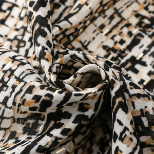 Detail of soft pashmina scarf with gold thread texture and abstract leopard print patterns