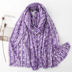 Close-up of purple geometric pixel scarf with gold threads and soft fringe edges