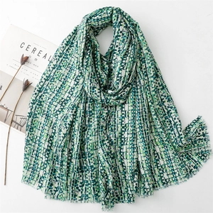 Detail of teal and white mosaic plaid scarf with soft fringed edges and linen feel