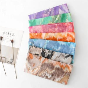 Macro detail of abstract linen-feel scarves with gold foil and colorful mountain patterns