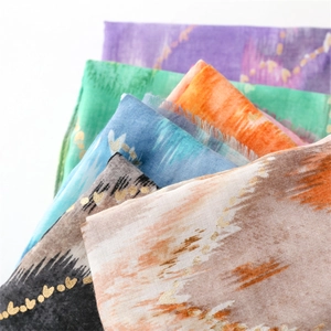 Detailed macro view of colorful watercolor scarves with golden heart foil print and frayed edges