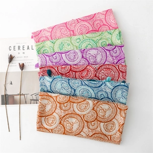 Close-up of assorted cotton-linen scarves with ethnic floral patterns and fringe details