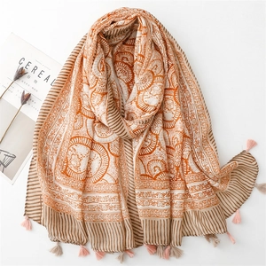 Bohemian orange cotton-linen scarf with mandala prints and fringe tassels on white background