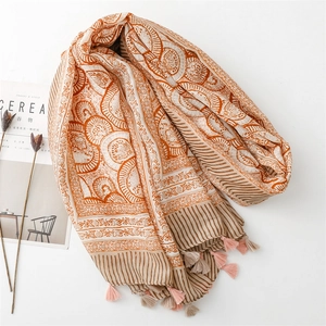 Detail of bohemian scarf with floral patterns, multicolor tassels, and linen texture