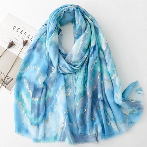 Detail of blue mountain pattern scarf featuring gold heart foil and frayed edges