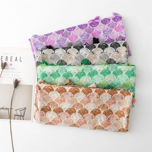 Detailed view of colorful seashell scale pattern scarves with delicate fringe tassels