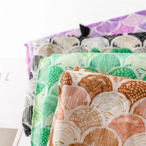 Detail of cotton linen scarves featuring shell patterns and fringed edges in various colors