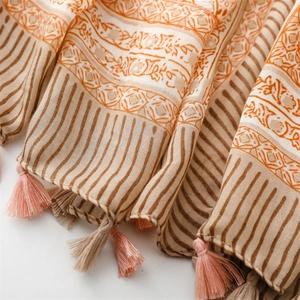 Detailed view of bohemian floral print scarf with intricate tassels and cotton-linen texture