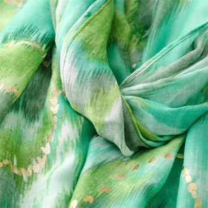 Macro detail of green wave pattern scarf with gold heart prints and fine stitching