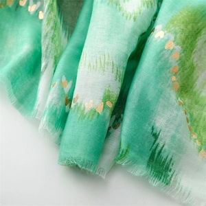 Detail of green linen scarf with gold heart foil and soft fringe edges