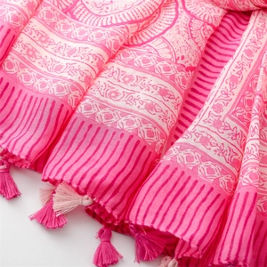 Macro shot of pink and white bohemian floral print fabric with dual-tone tassels