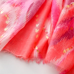 Detail of pink cotton scarf with gradient wavy patterns and gold heart foil print