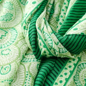 Close-up of green paisley lotus pattern and striped edge on cotton linen feel scarf