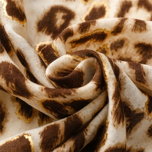 Macro shot of leopard print scarf with luxury gold foil stamping detail and soft texture