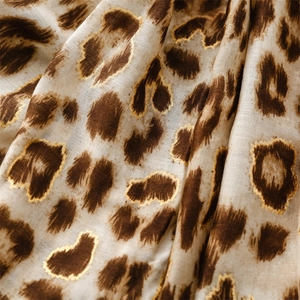 Detail of leopard print scarf featuring golden foil accents on soft cotton-linen fabric