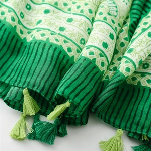 Detailed macro view of green floral cotton linen scarf with soft fringe tassels