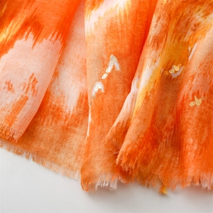 Macro detail of cotton-linen scarf fabric with golden foil print and frayed edges