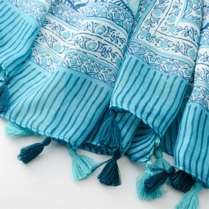 Close-up of bohemian blue floral scarf with elegant fringe tassels and linen texture
