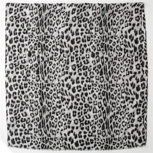 Detail of leopard print scarf with fine fringe edges and cotton linen texture