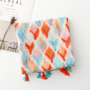 Close-up of geometric diamond print scarf with colorful orange and blue tassels