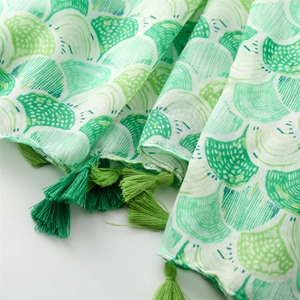 Detailed texture of green shell pattern linen scarf with handmade emerald tassels