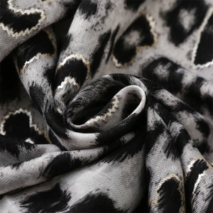 Detail of leopard print scarf with golden metallic edges and fine woven fiber texture