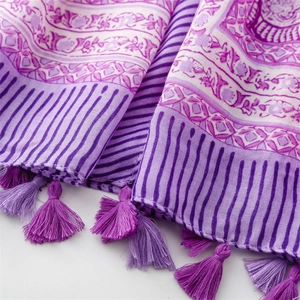 Detail of purple floral scarf featuring striped patterns and delicate fringe tassels