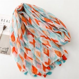 Detailed shot of bohemian geometric scarf with colorful fringe on white surface