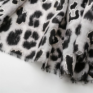 Macro view of grey leopard print scarf with silver glitter edges and frayed hem texture
