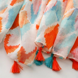 Detail view of lightweight summer scarf with colorful geometric print and tassels