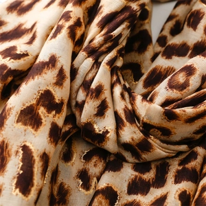 Close-up of leopard print scarf featuring luxurious gold foil details and soft texture