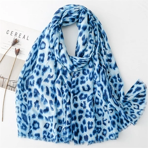 Close-up of blue leopard print scarf with fringed edges on minimalist white background