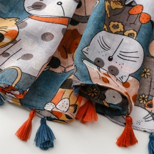 Vue détaillée d'une écharpe en coton avec motif chat et pompons colorés