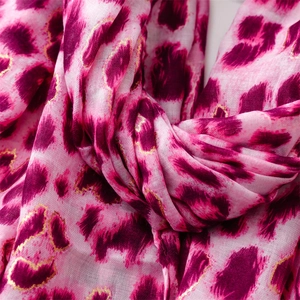 Detail of pink leopard print scarf featuring elegant gold foil accents and soft texture