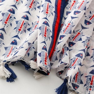 Détail de l'écharpe en coton et lin avec motifs de poissons rouges et bleus et franges